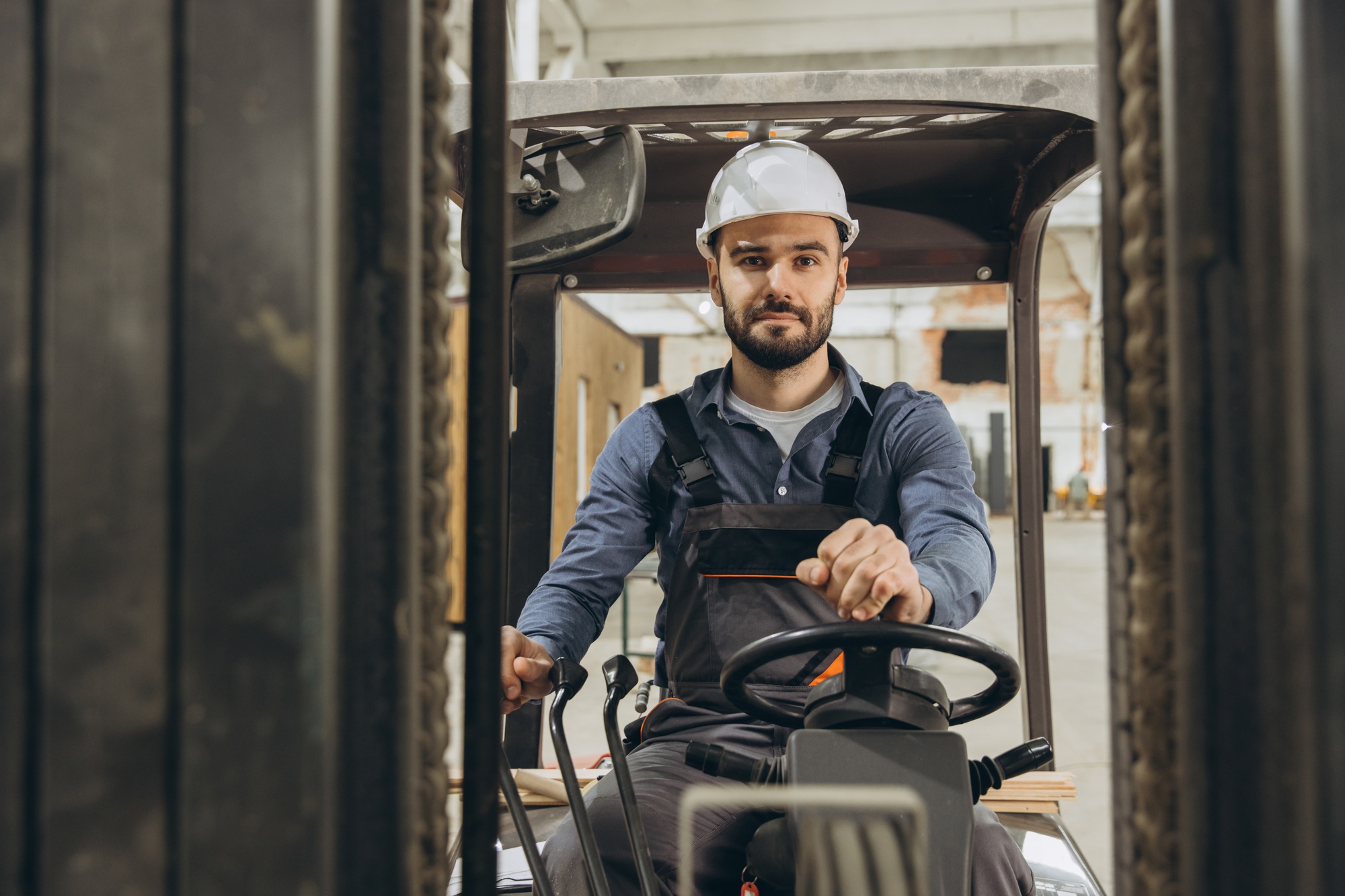 Forklift operator driving in modular building factory